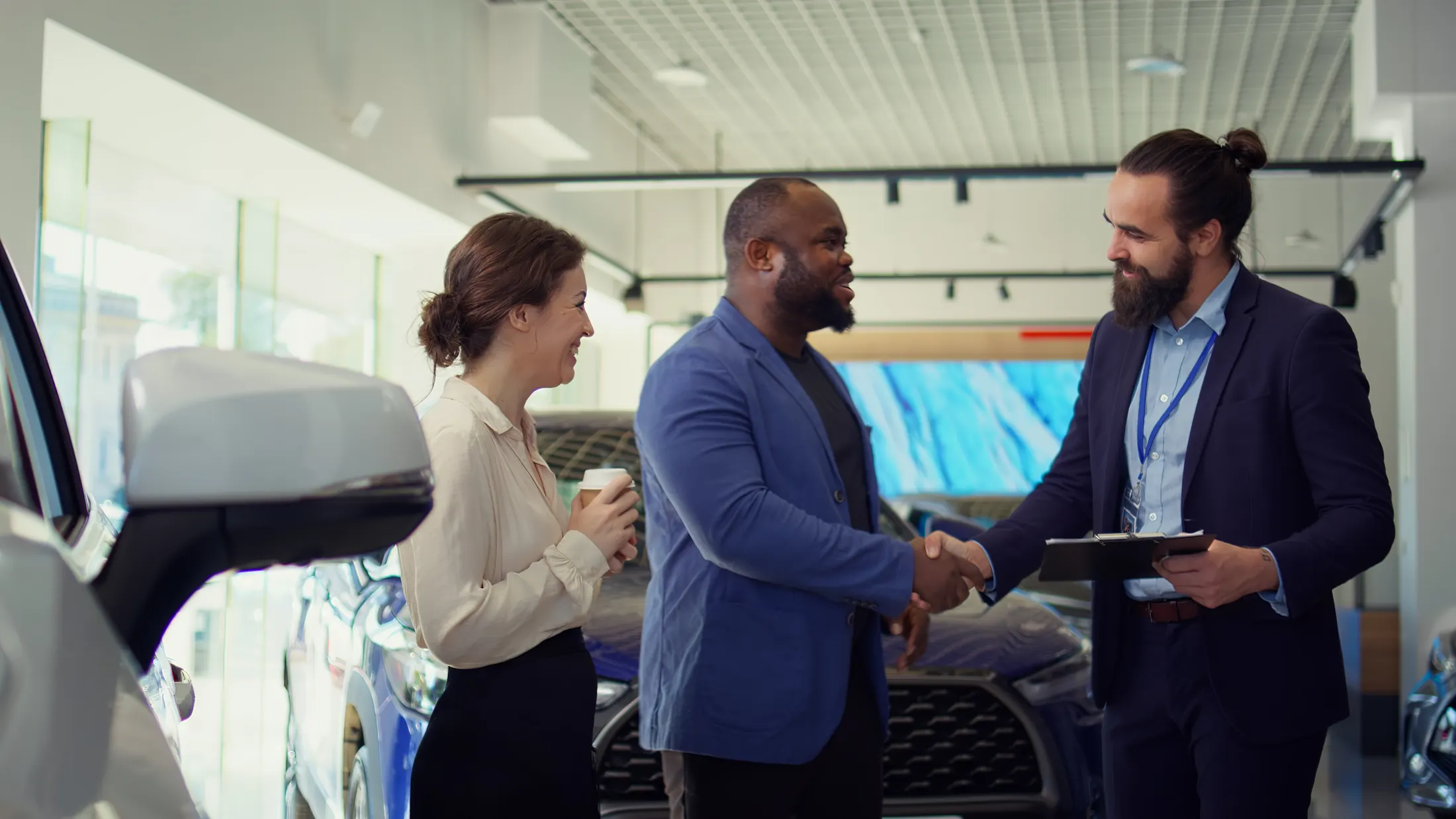 Dealership salesperson greeting customers in a showroom